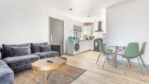 A modern apartment with a living room, kitchen, and dining area. - Hotel Koxie (Los Angeles)