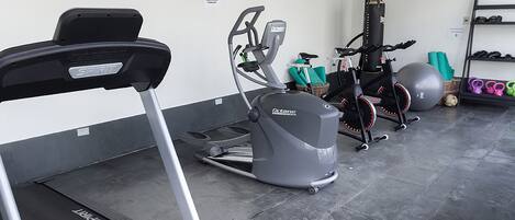 A gym with treadmills, an elliptical, and a stationary bike.