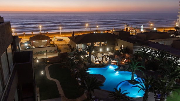 Un resort con piscina, vista al mar y zonas de estar al aire libre.