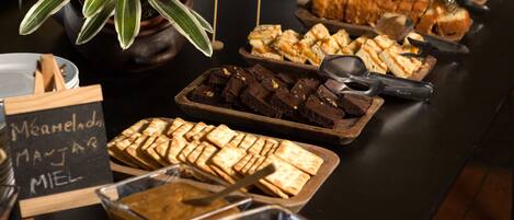 A buffet table with various food items including brownies, pastries, and a sign indicating 'Marmalade, Manjar, Miel'.