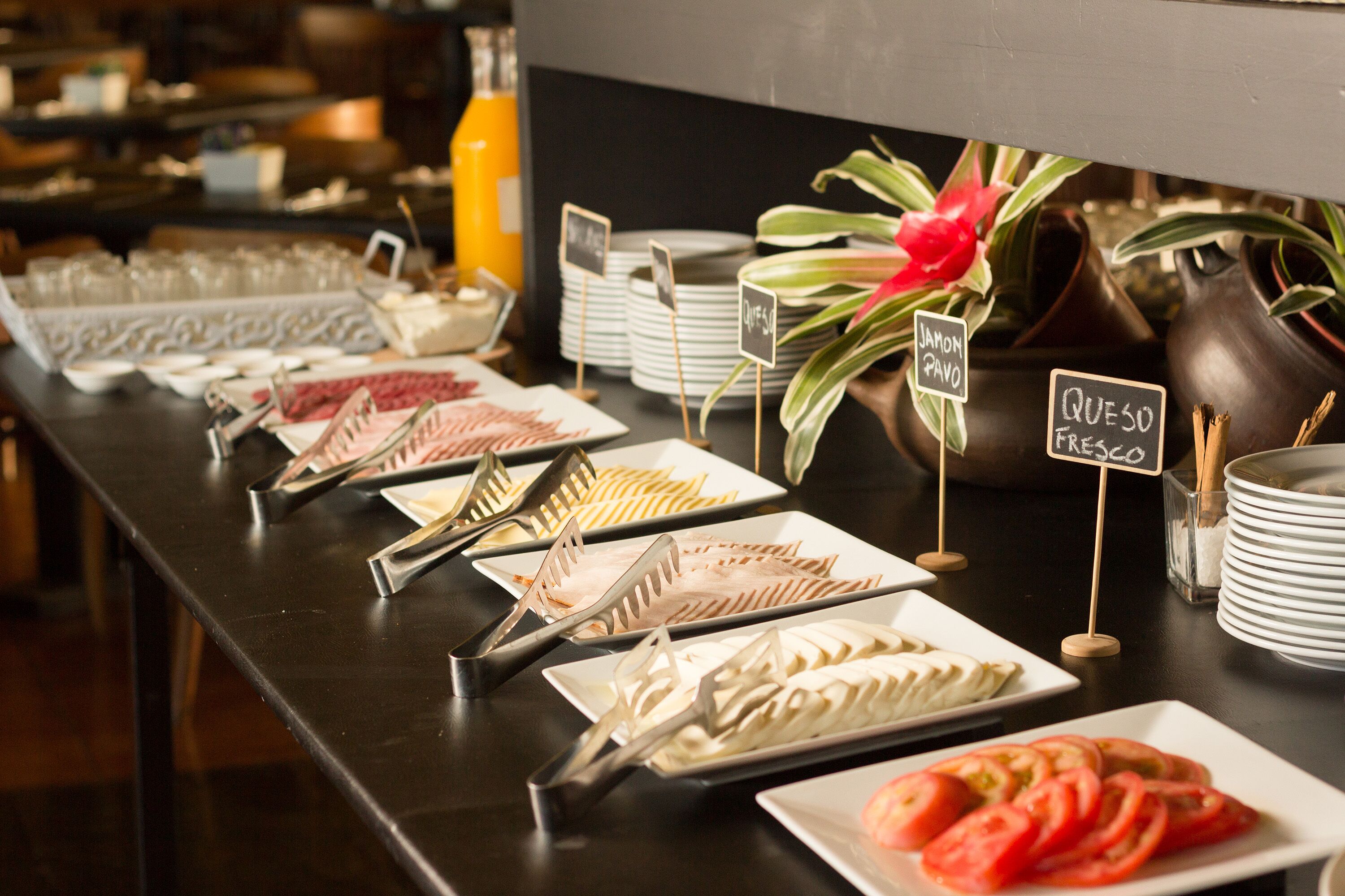 Una mesa de buffet con distintos alimentos y utensilios para servir.
