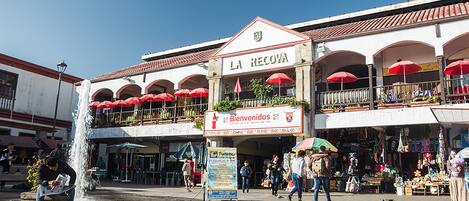 A building with a sign reading "LA RECOVA" and "Bienvenidos" welcoming visitors.