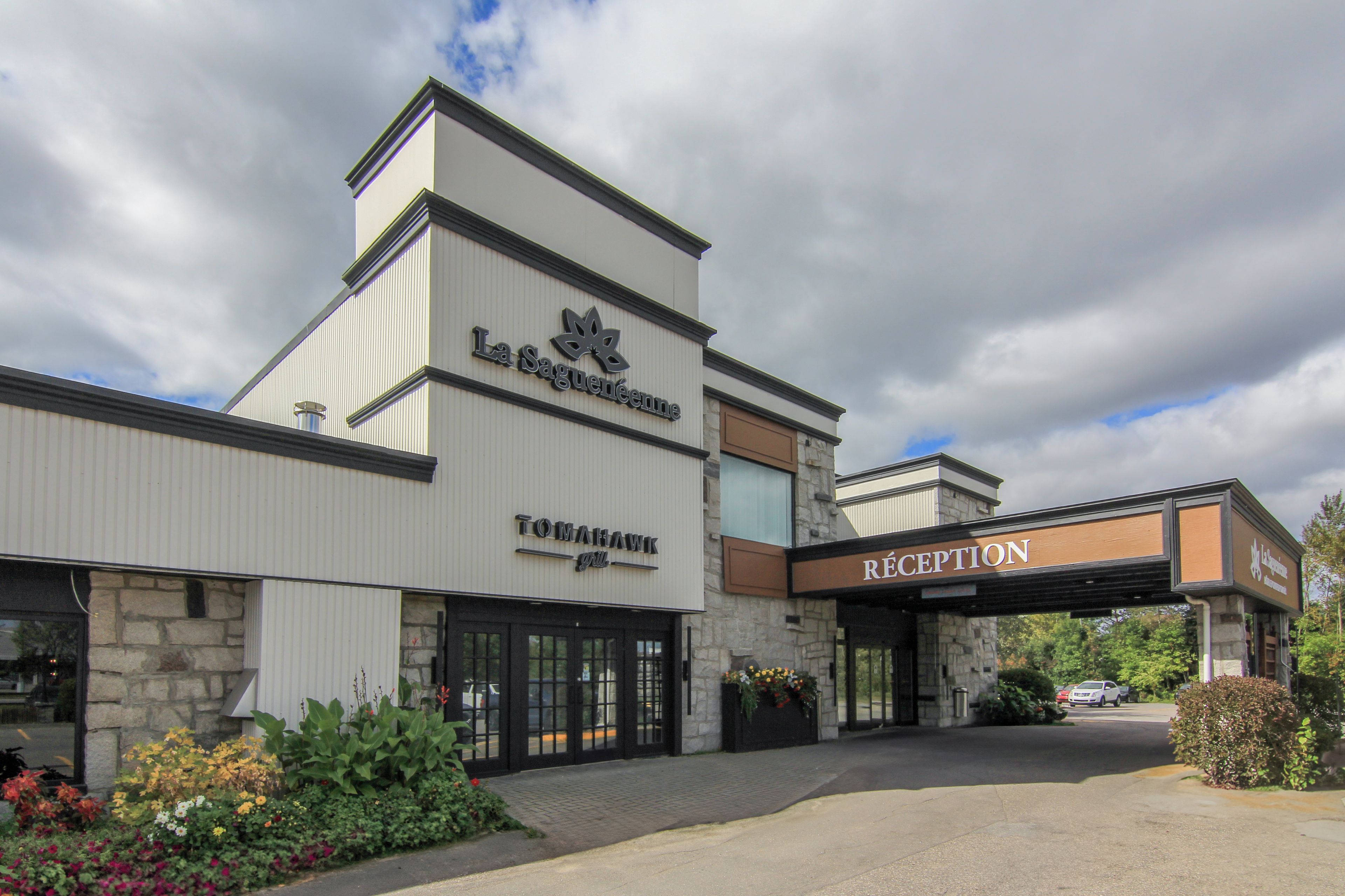 En byggnad med en skylt som visar namnen ”La Saguénne” och ”TOMAHAWK grill” på fasaden.