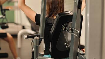 Eine Person trainiert mit einer Beinpresse im Fitnessstudio.
