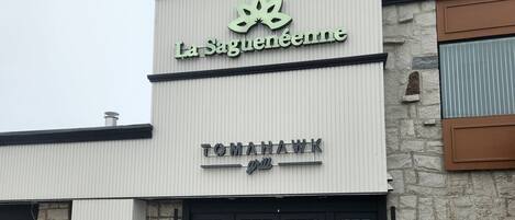 A building with a sign for "La Saguénée" and "TOMAHAWK grill".