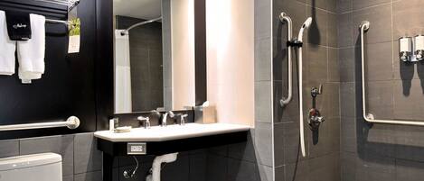 A modern bathroom with a shower, toilet, and sink.