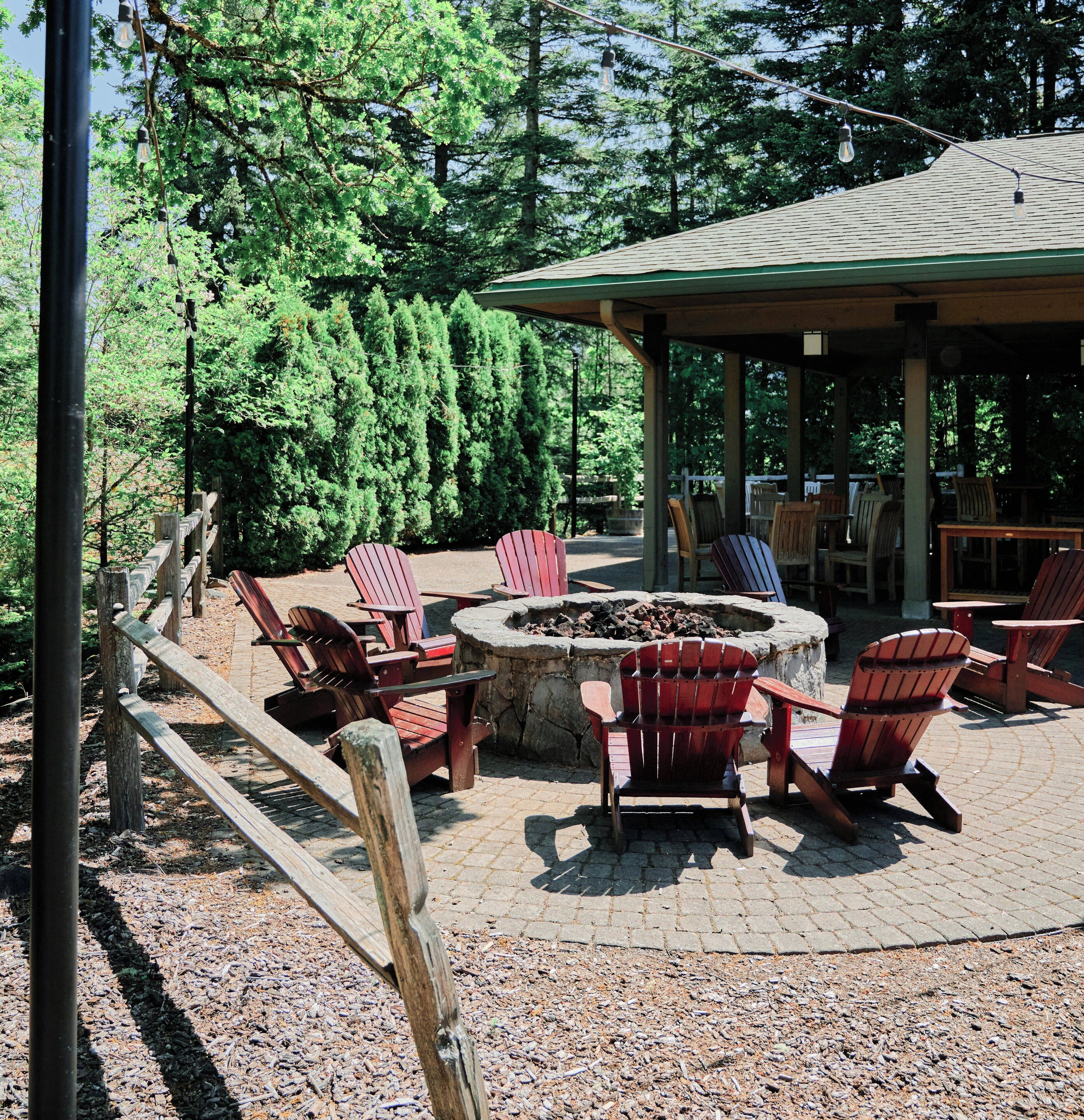 Un espace extérieur aménagé avec des chaises Adirondack et un foyer.