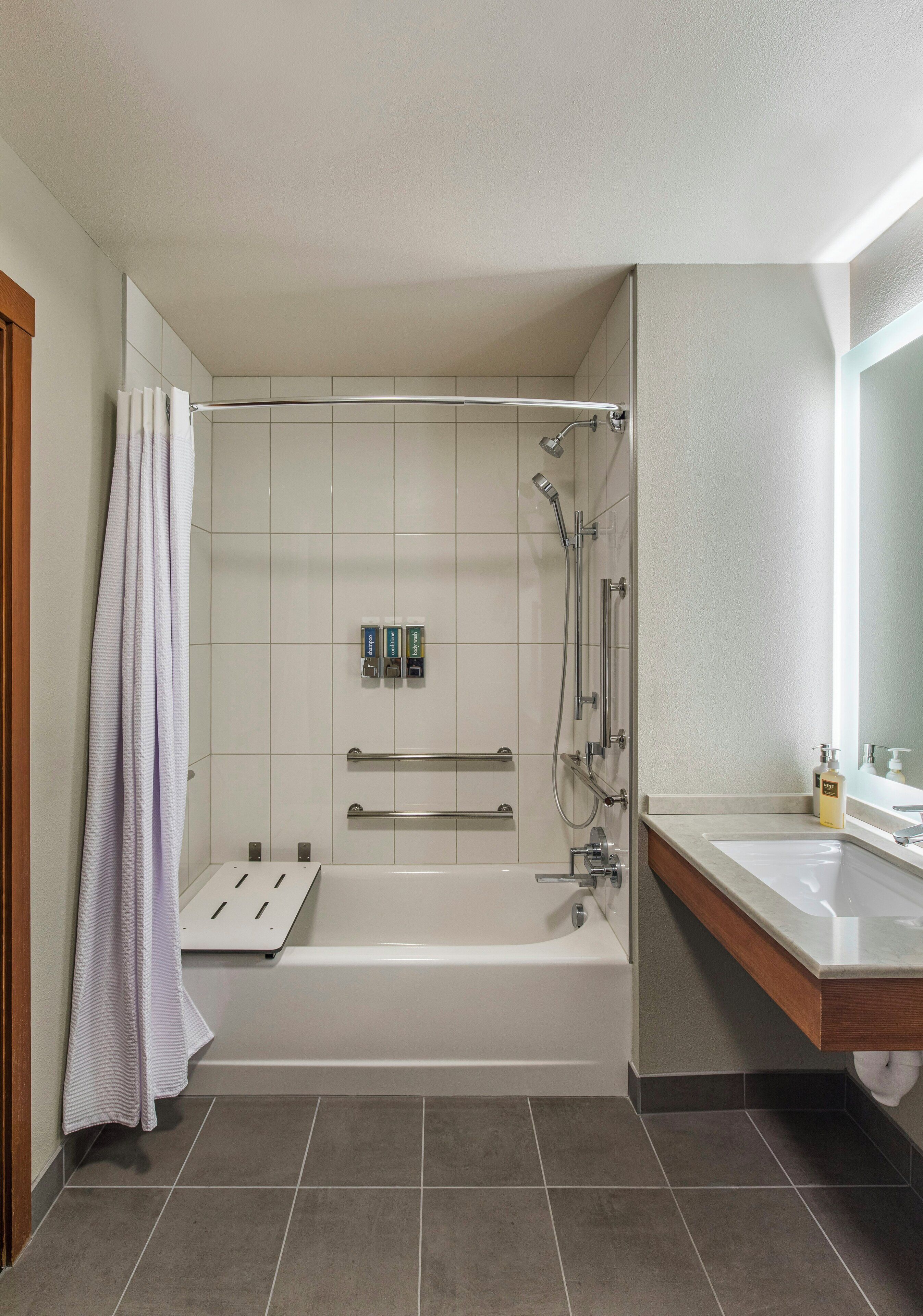 A modern bathroom with a bathtub, shower, and vanity.
