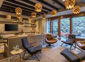 Un intérieur moderne comprenant un comptoir d’accueil, un espace salon et de grandes fenêtres donnant sur un paysage naturel.