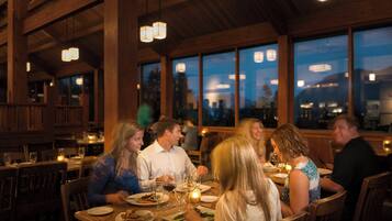 A restaurant with wooden interiors and large windows.