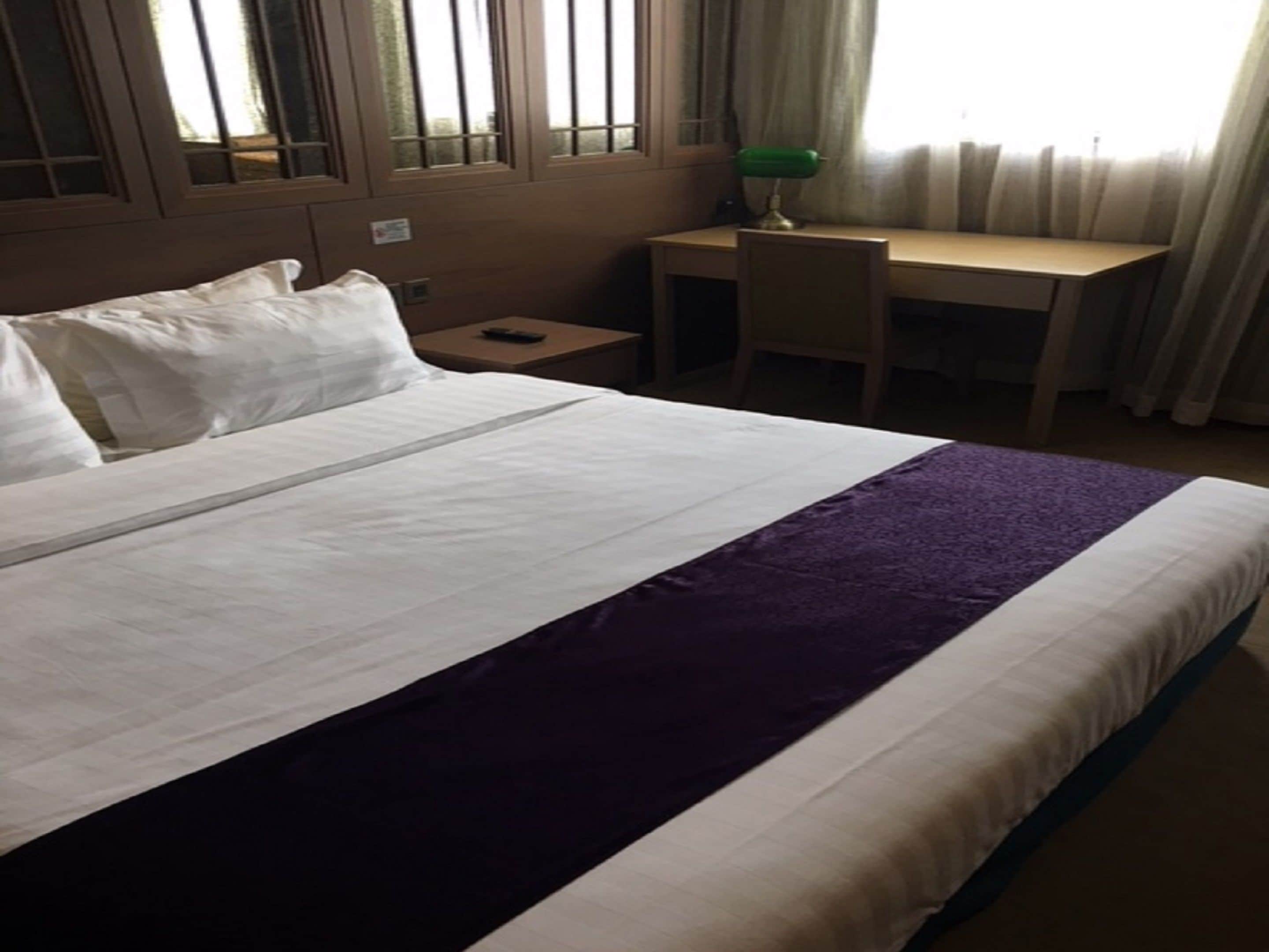 Habitación de hotel con una cama grande, un escritorio y una silla.