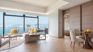 Un soggiorno moderno con un'ampia finestra, un'area pranzo e vista sulla città e sull'acqua.