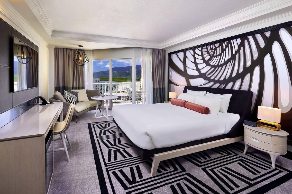 Une chambre d’hôtel équipée d’un lit, d’un bureau, d’une chaise et offrant une vue sur l’extérieur.