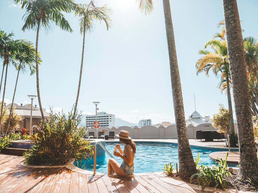 Una piscina al aire libre, sillones reclinables de piscina