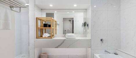 A modern bathroom with a glass shower enclosure, a wooden vanity with a mirror, a bathtub, and a toilet.