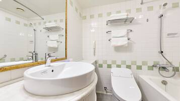 A modern bathroom with a white sink, a toilet, and a bathtub. There are towel racks on the wall and a mirror above the sink.