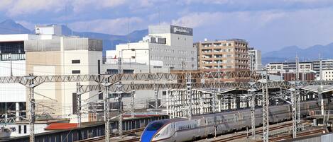 Una estación de tren moderna con varias vías y un tren de alta velocidad.