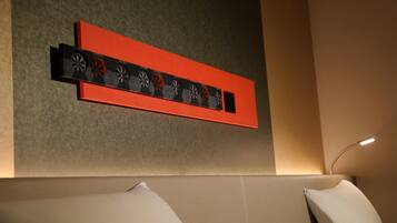 Una habitación de hotel moderna con una paleta de colores neutros, un adorno en la pared y un diseño minimalista.