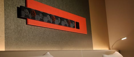 A modern hotel room with a neutral color scheme, a decorative wall piece, and a minimalist design.