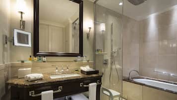 A modern bathroom with a large mirror, a sink, a shower, and a bathtub.