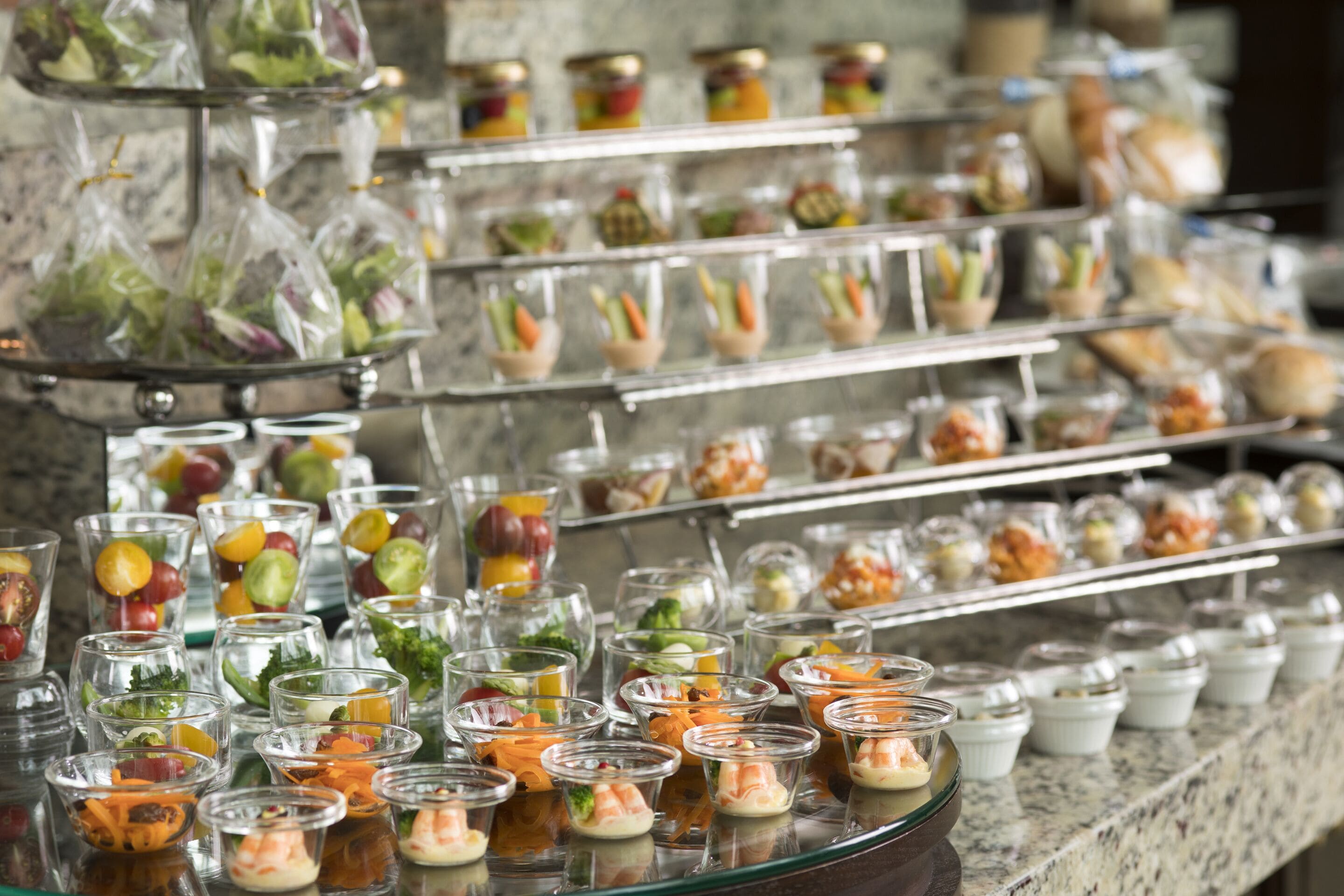 A buffet with various food items arranged on multiple tiers.