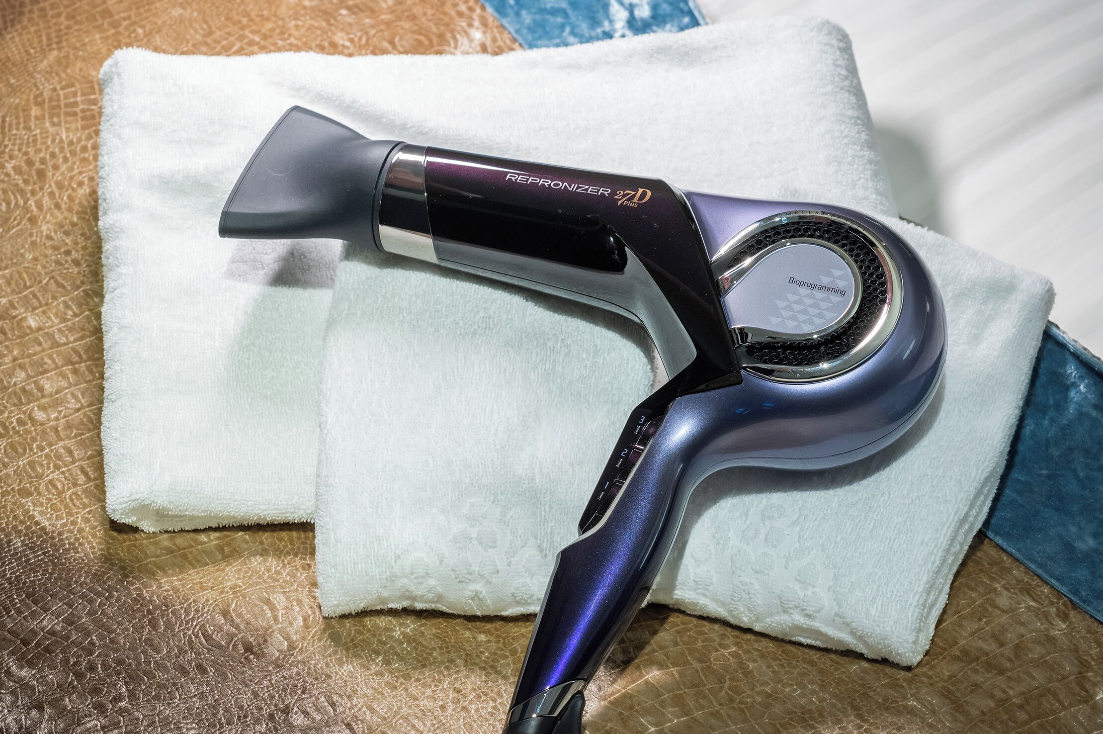 A hairdryer with a digital display on a textured surface.