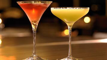 Duas taças de martini sobre uma superfície refletora.
