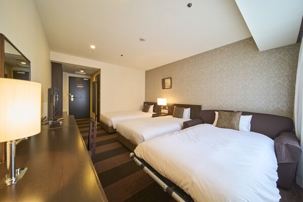 A hotel room with three single beds, a desk with a lamp, and a mirror. - Hotel Granvia Wakayama (Wakayama)