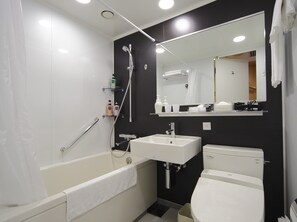 Een moderne badkamer met een bad, wastafel en toilet.