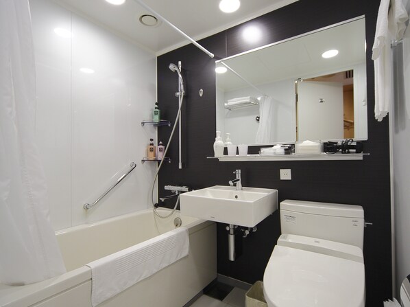 Un baño moderno con bañera, lavamanos e inodoro.