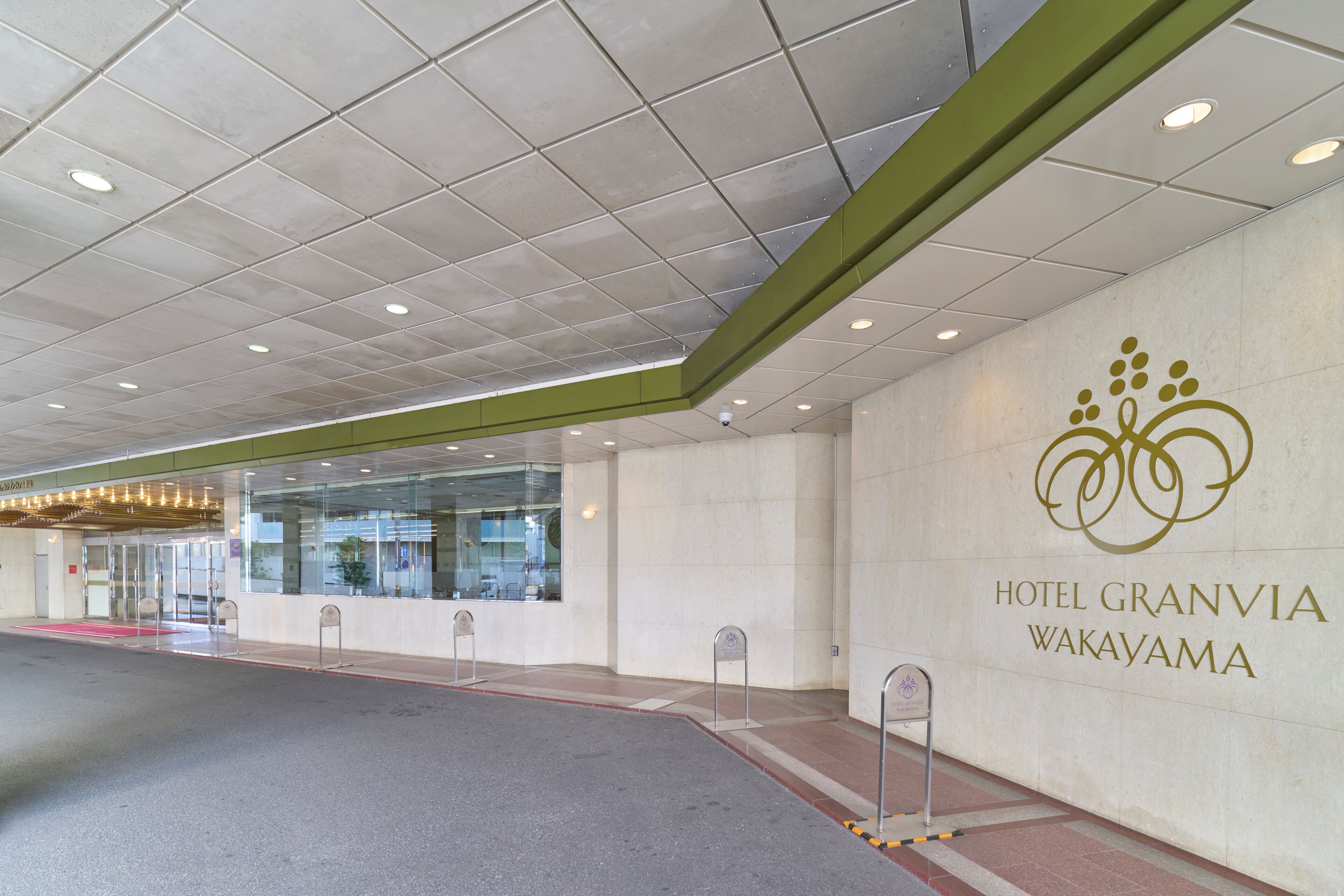The entrance of Hotel Granvia Wakayama with a modern design, glass doors, and a clear sign.