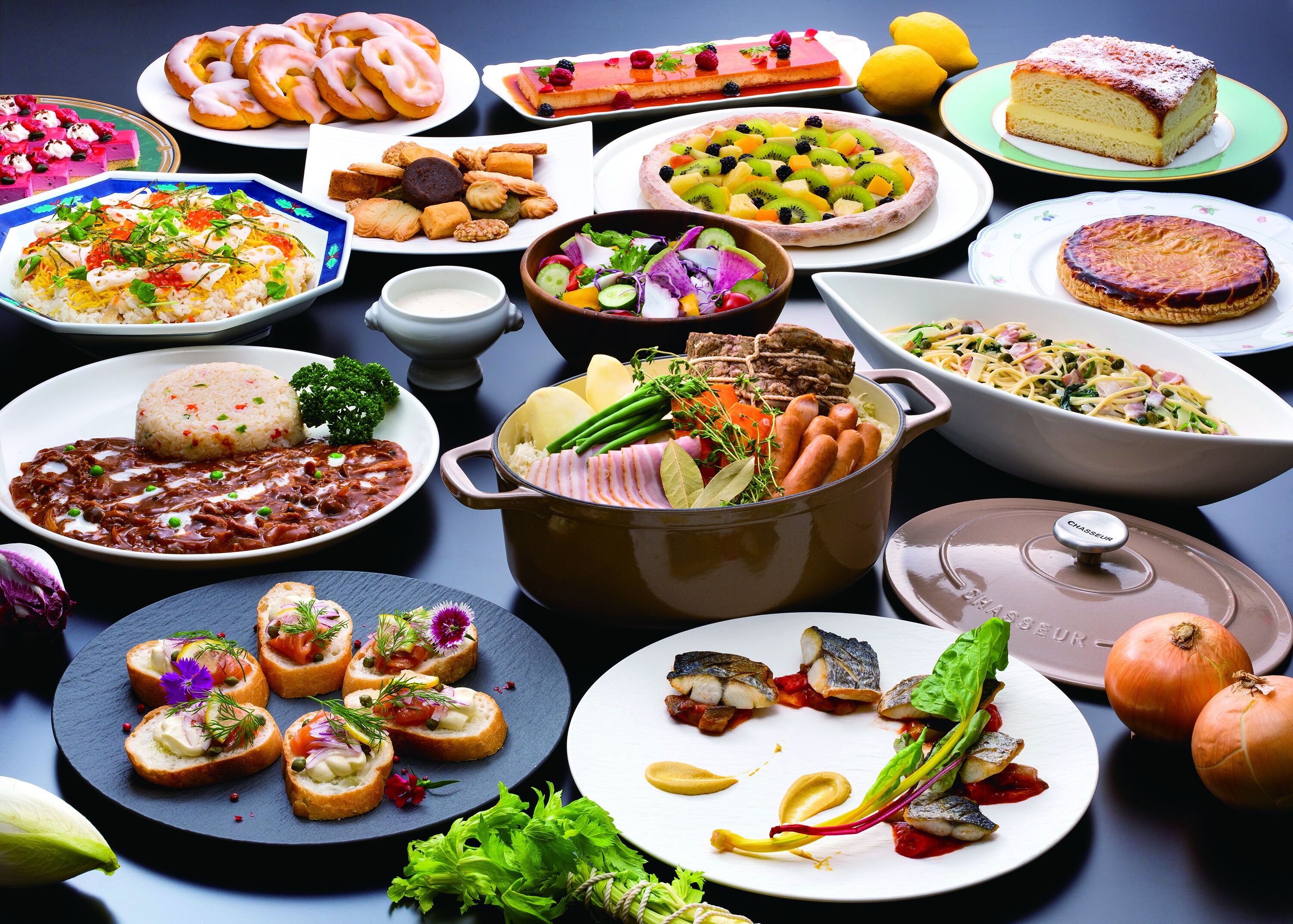 A variety of dishes and food items on a table, including pastries, salads, and a pot of food.