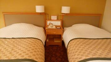 A hotel room with two single beds, each with a headboard and a bedside table with a lamp.