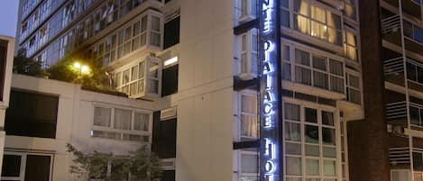 A multi-story hotel with a prominent sign reading "Royal Plaza Hotel." The building features large windows and a glass entrance area.