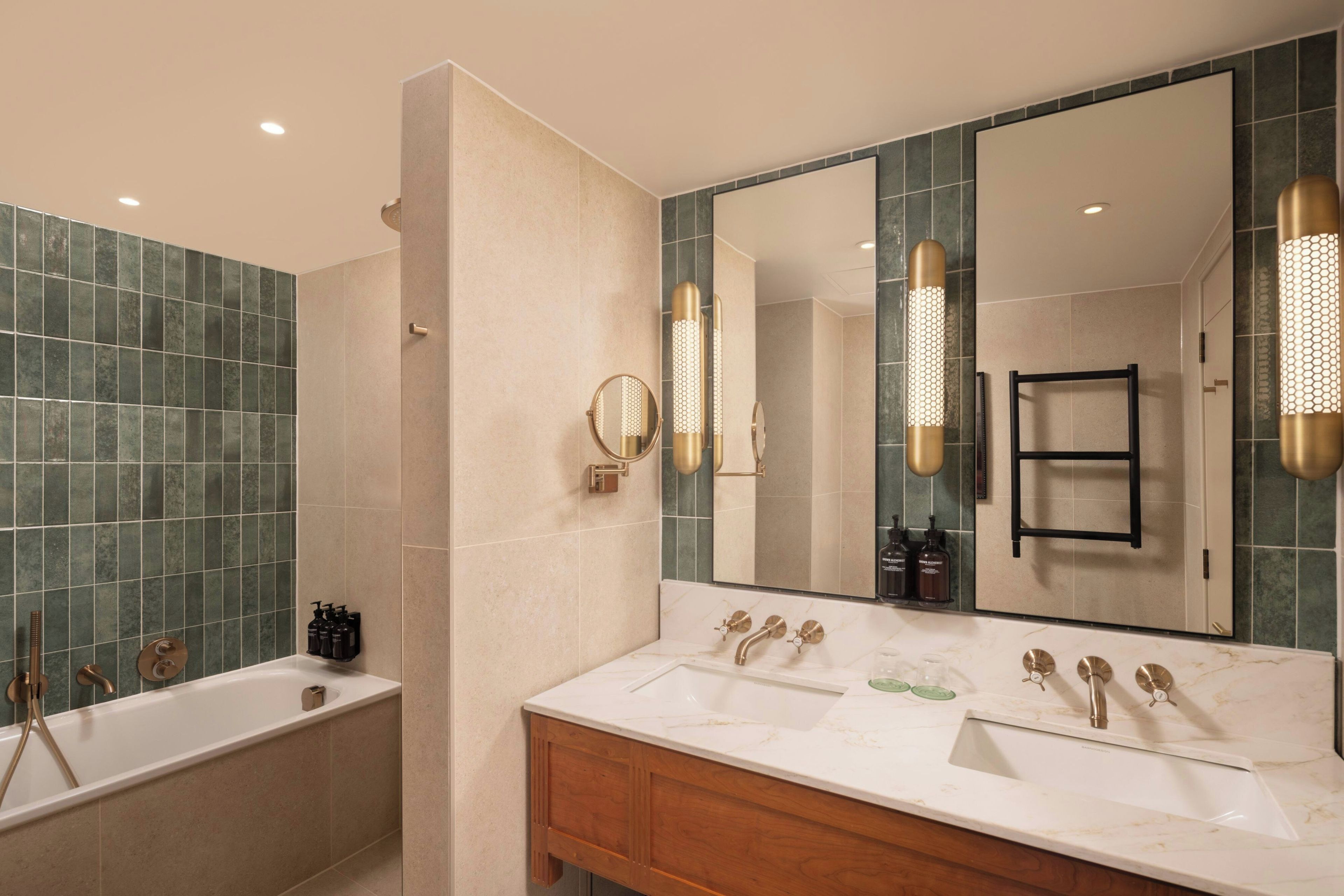 A modern bathroom with a bathtub, a vanity with a mirror, and a large mirror reflecting the room.