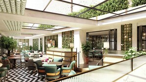 A spacious indoor area with multiple seating arrangements, a staircase, and a bar area. - Hyde & Seek, London Hyde Park, a Tribute Portfolio Hotel (London)