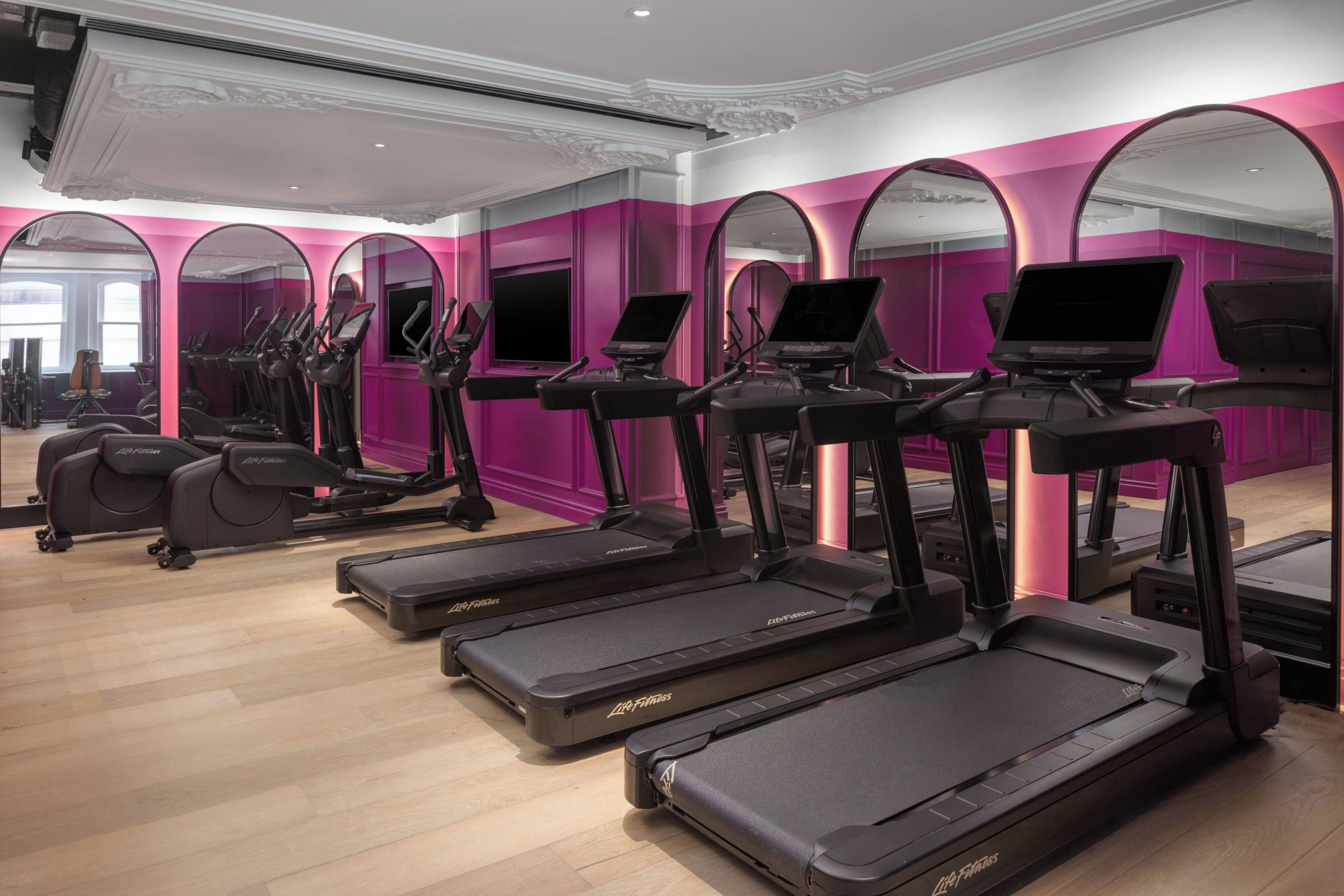 A fitness center with treadmills, elliptical machines, and exercise bikes.