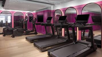 Et fitnesscenter med løbebånd, crosstrainere og motionscykler.