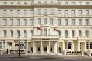A large, stately building with a symmetrical facade, multiple windows, and a prominent entrance with a sign reading 'HYDE & SEEK'. - Hyde & Seek, London Hyde Park, a Tribute Portfolio Hotel (London)