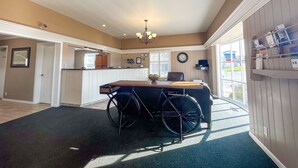Amplia habitación con una silla de ruedas, zona de comedor y vistas al exterior.