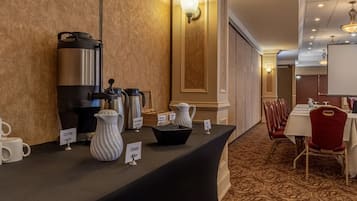 Habitación de hotel con estación de café, jarra de crema y una pizarra.