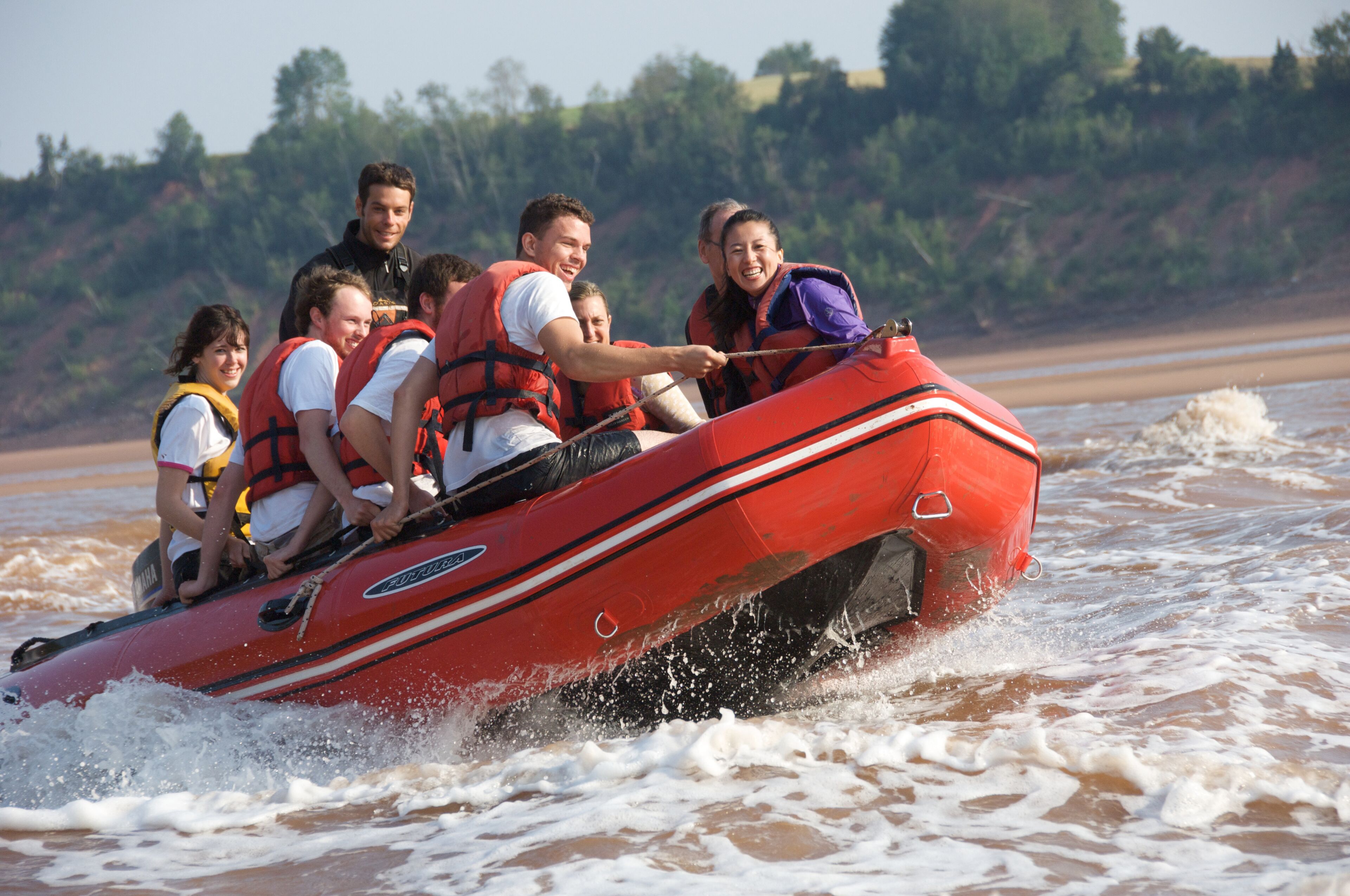 Un grupo de personas en una balsa inflable roja en un río.