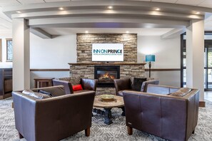 A modern lounge area with leather sofas, a central coffee table, a stone fireplace, and a sign for 'INN ON PRINCE HOTEL & CONFERENCE CENTRE TRURO.' - Inn on Prince Hotel & Conference Centre, an Ascend Collection Hotel (Truro)