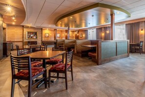 A restaurant with a curved ceiling, wooden walls, and a mix of booth and table seating. - Inn on Prince Hotel & Conference Centre, an Ascend Collection Hotel (Truro)