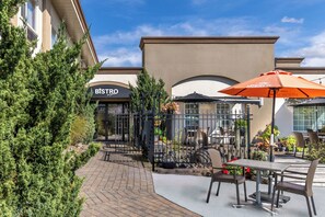 An outdoor patio area with a bistro restaurant, outdoor seating, and potted plants. - Inn on Prince Hotel & Conference Centre, an Ascend Collection Hotel (Truro)