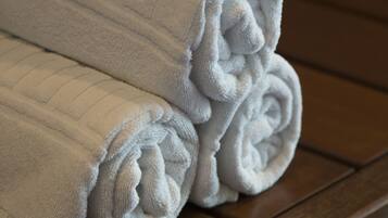 A stack of white towels on a wooden surface.