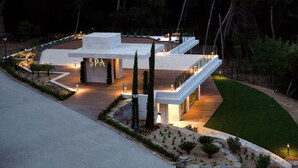 Un moderno complesso termale con un'ampia entrata, illuminazione esterna e un giardino curato.