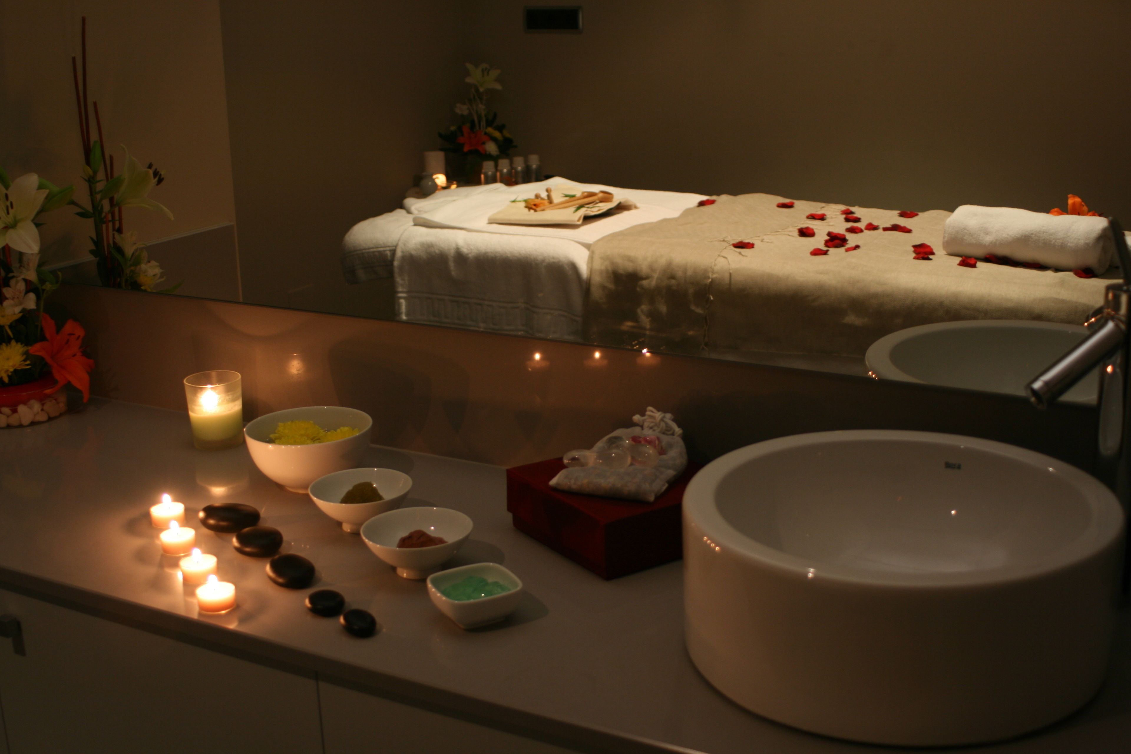 A spa area with a massage table, candles, and various toiletries.
