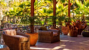 An outdoor seating area with wicker furniture and potted plants.
