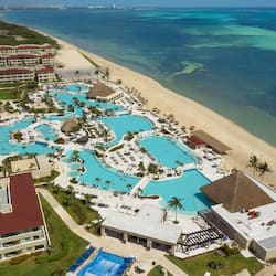 Relax by the resort's central swimming area, surrounded by amenities and a pristine beach.